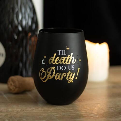 Celebrate with the Til Death Do Us Party Stemless Wine Glass, featuring a playful skeleton design in black and gold.