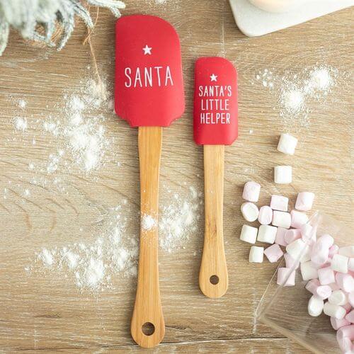 Santa's Helper Silicone Spatula Set featuring Santa and Little Helper designs on red silicone heads and wooden handles.