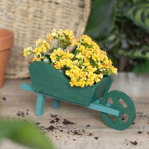 Whimsical Green Resin Wheelbarrow Planter filled with vibrant yellow flowers, perfect for charming garden displays.
