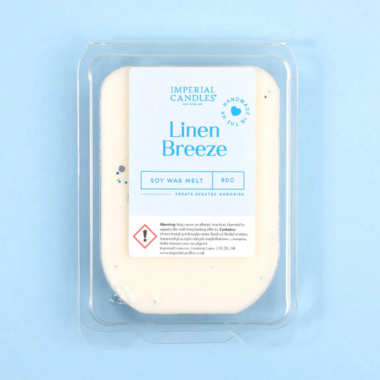 A 90g bar of Imperial Candles 'Linen Breeze' soy wax melt in a clear plastic clamshell package, set against a solid light blue background.