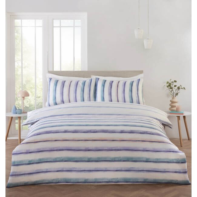 Striped bedding set on a bed in a bright bedroom