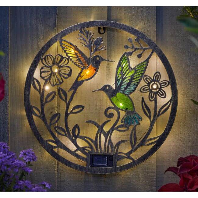 Decorative wall art with hummingbirds and flowers on a wooden background