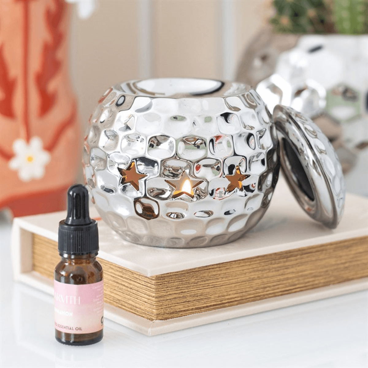Silver disco ball dolomite oil burner with star cutouts, 10 × 10.7 × 10 cm, for fragrance oil diluted in water.