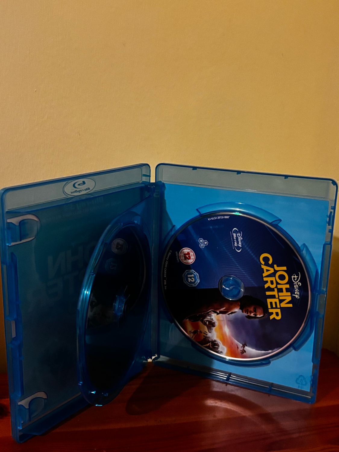 John Carter (Blu-ray 3D / Blu Ray 2D) [Region Free] set showcasing discs in a blue case from Walt Disney Studios.