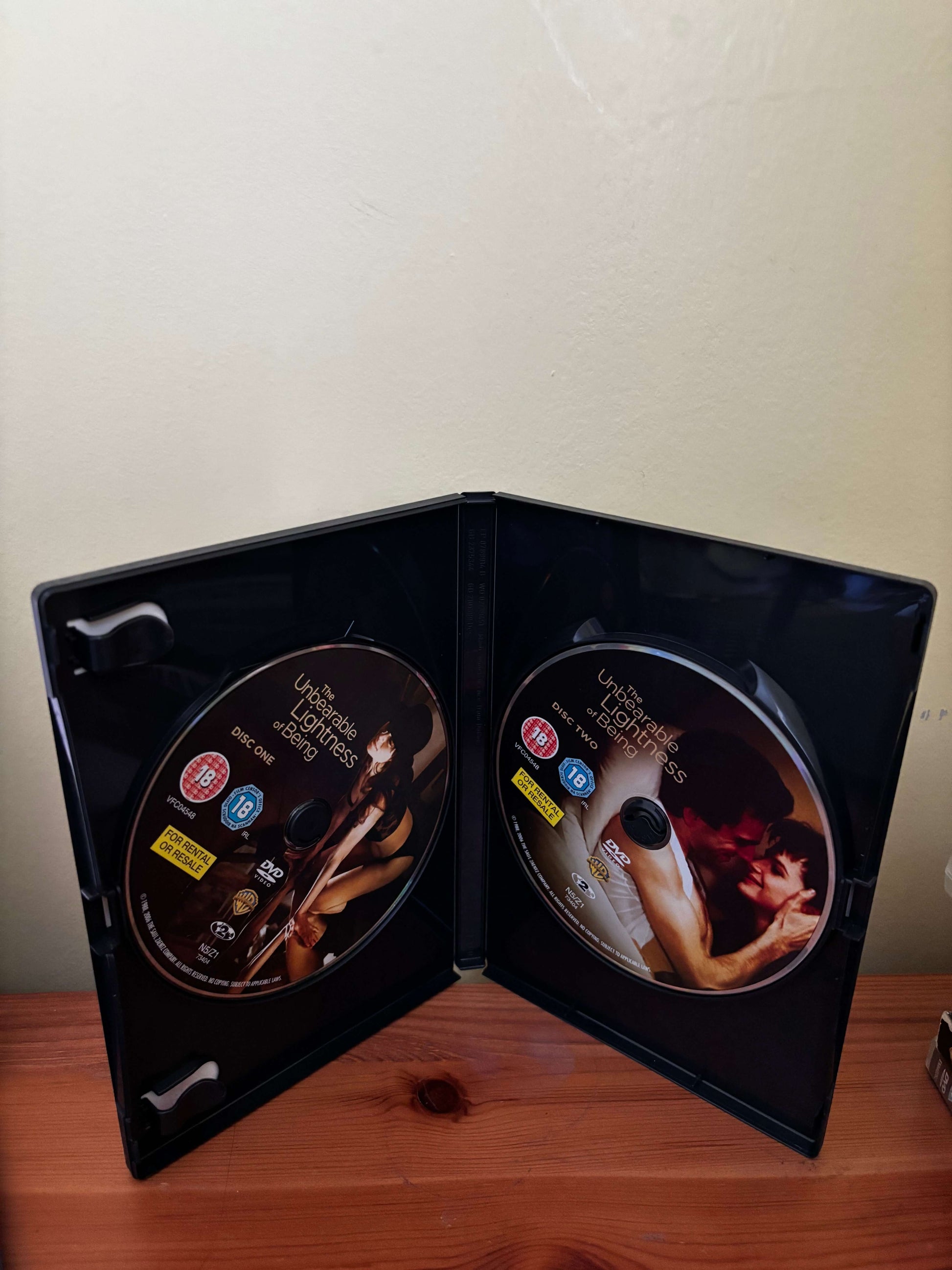 Two DVD covers with a couple on a wooden surface