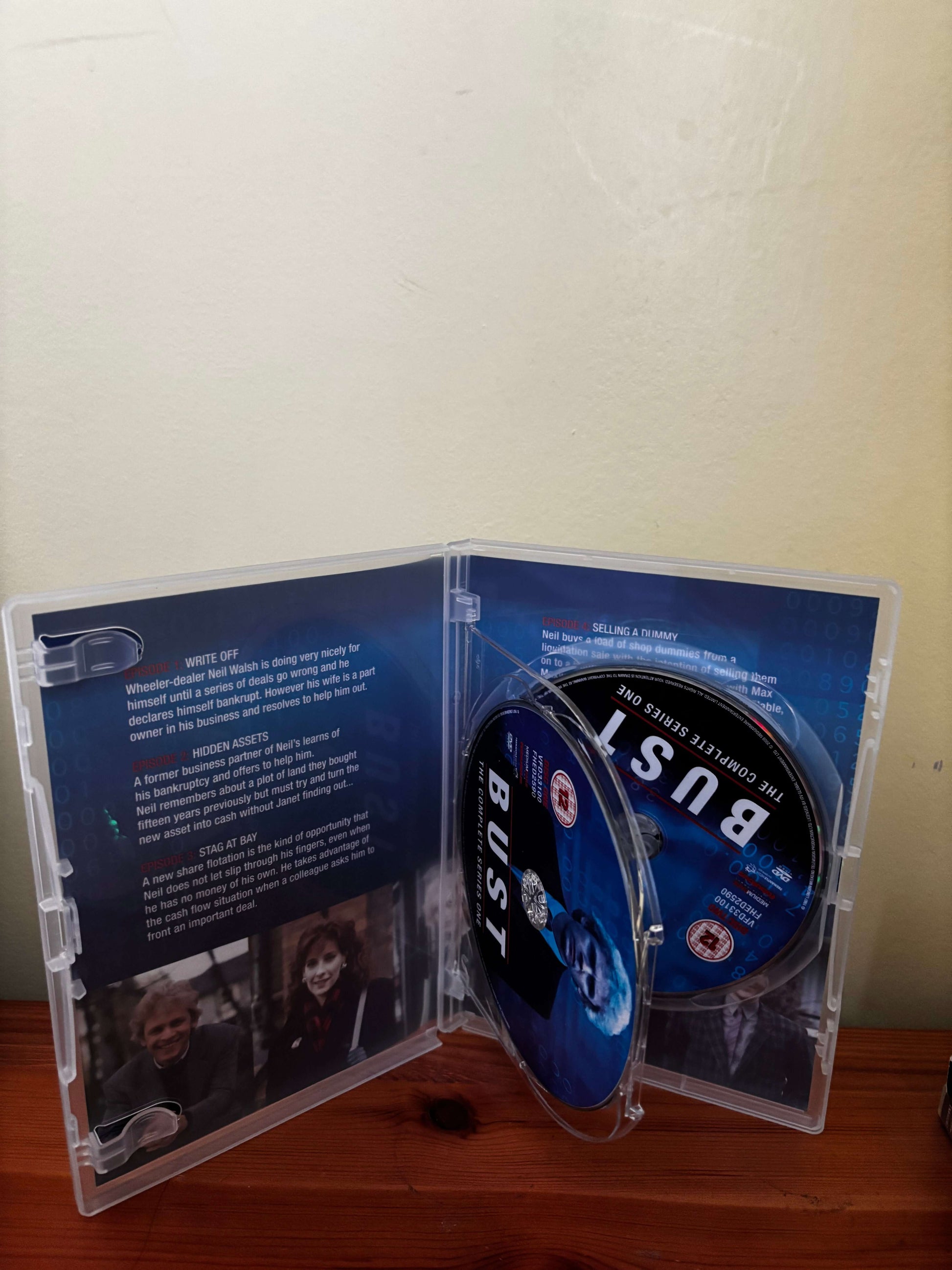 Open DVD case with 'BUSY' disc inside on a wooden surface.