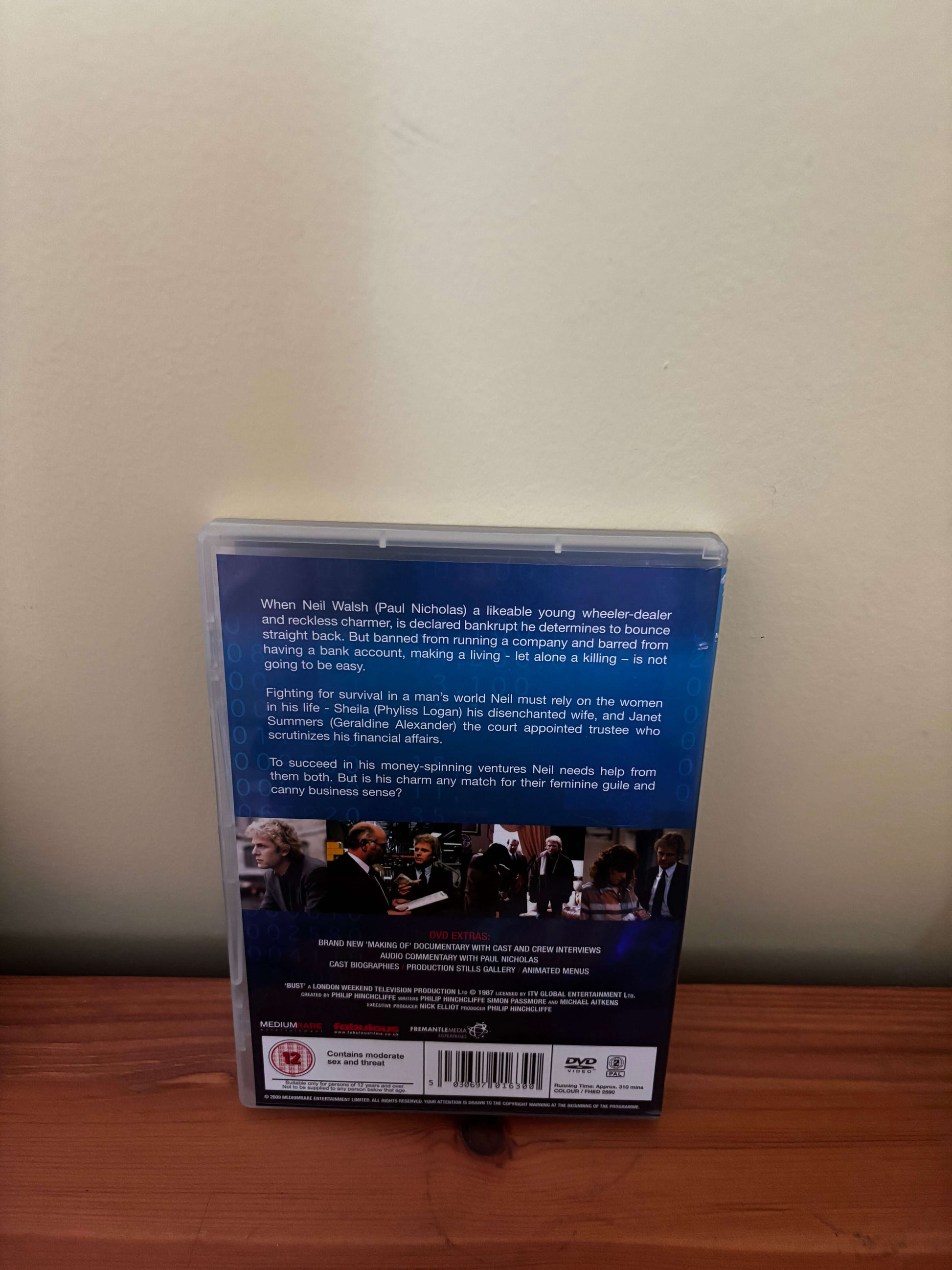 DVD case on a beige surface with a wooden edge