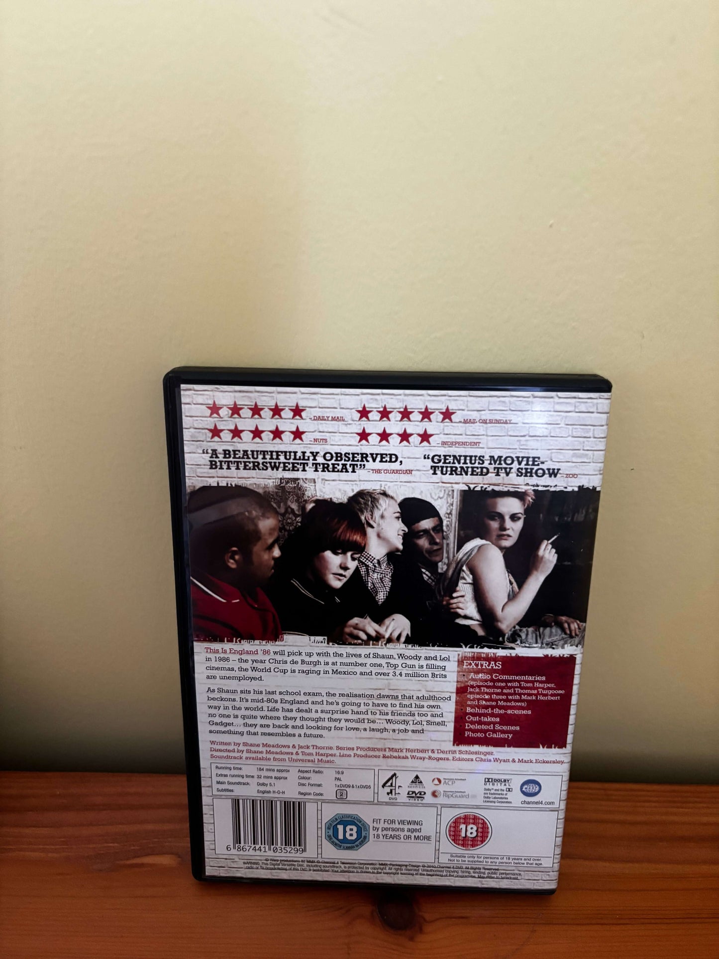DVD case with movie cover on a wooden surface and beige wall background