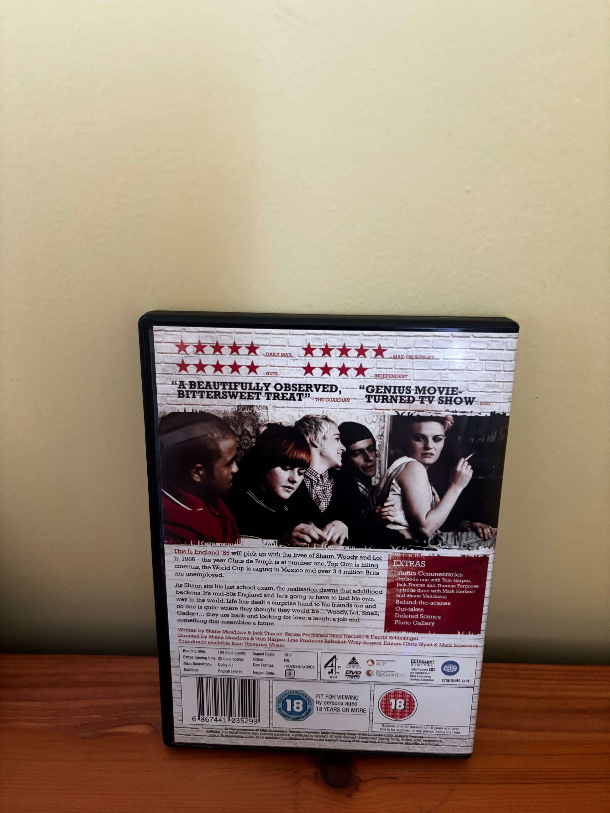 DVD case with movie cover on a wooden surface and beige wall background