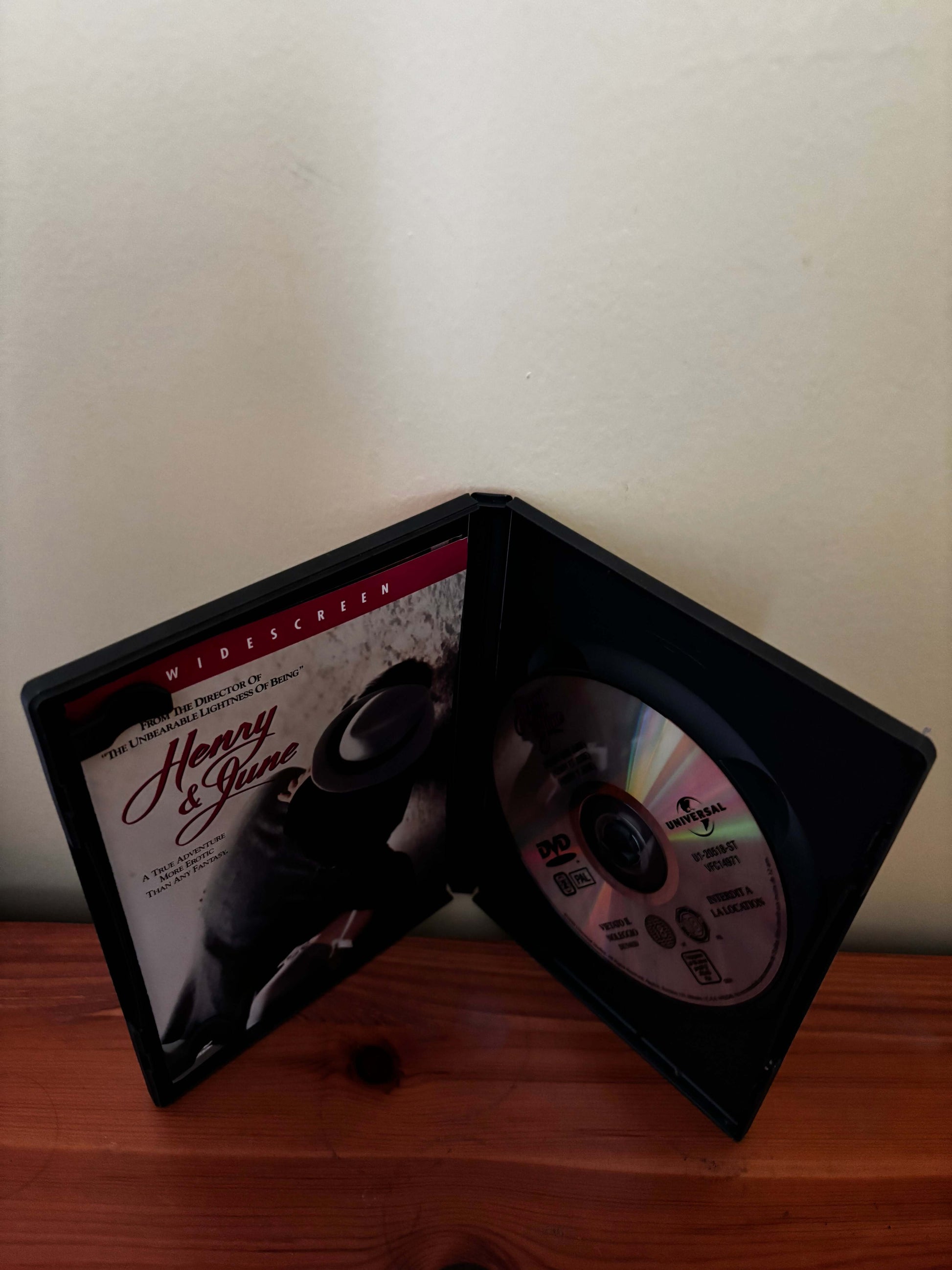 DVD case with a disc inside on a wooden surface