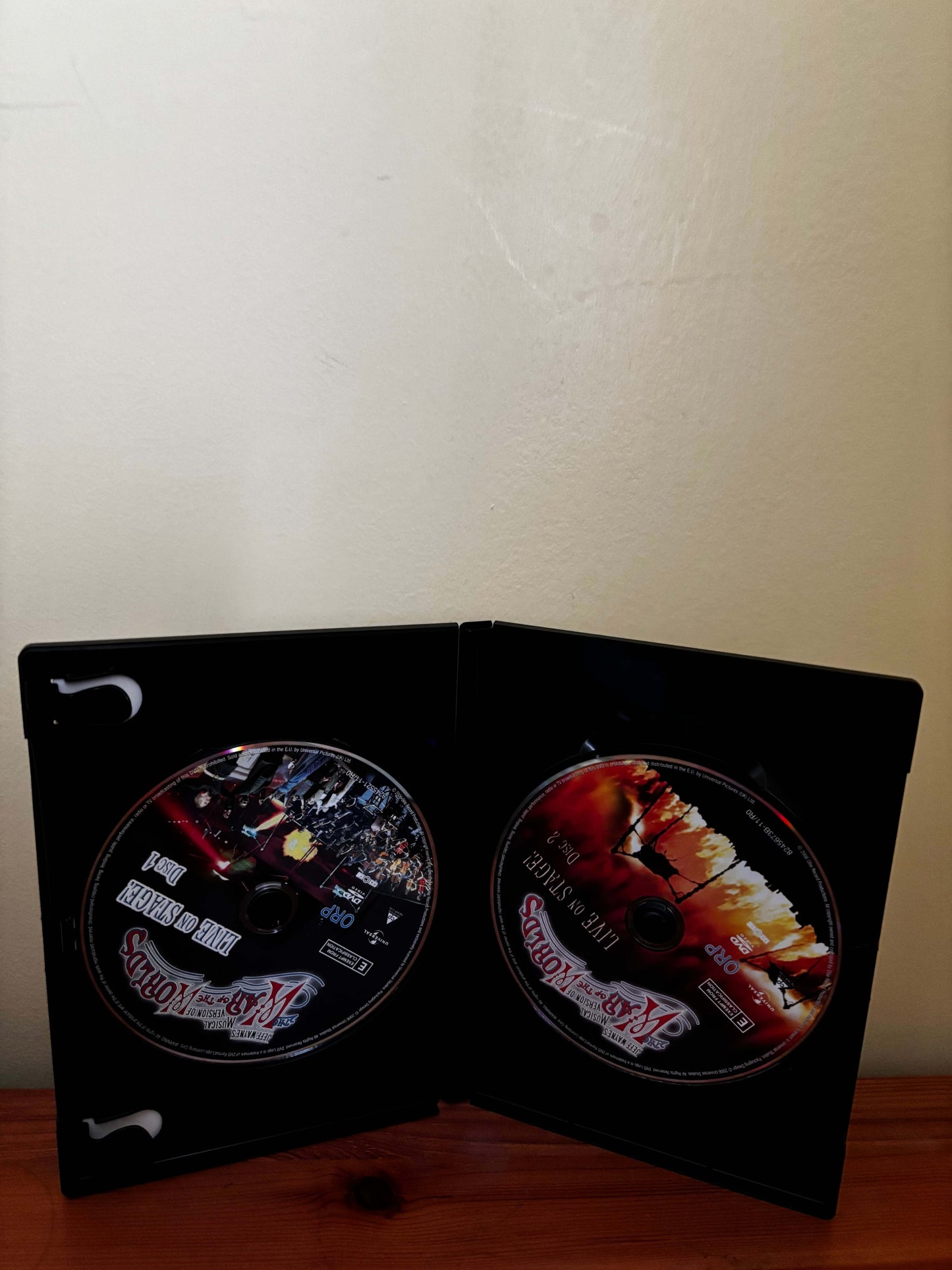 DVD case with two discs inside on a wooden surface