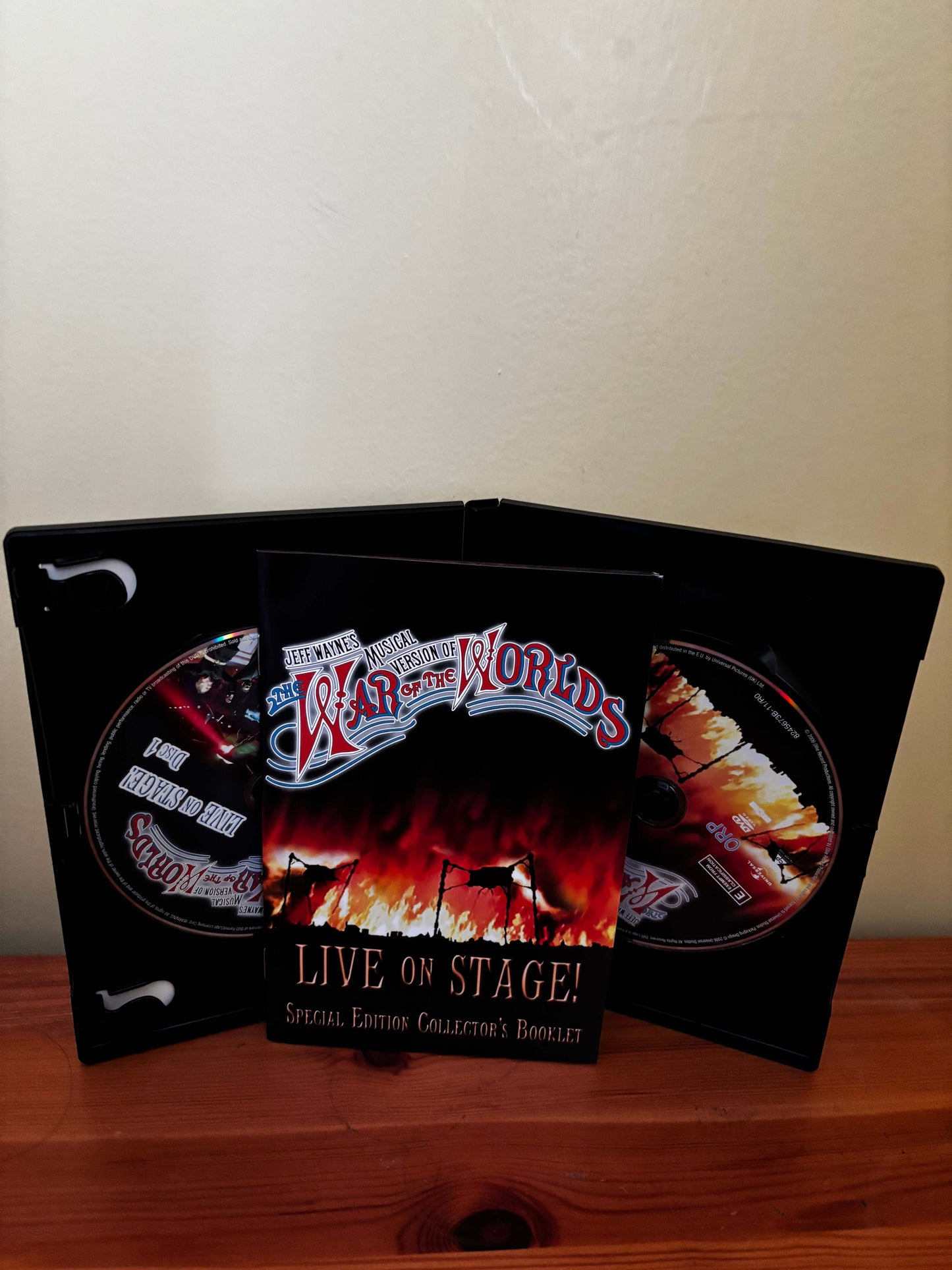 Product packaging with 'War of the Worlds' branding on a wooden surface.