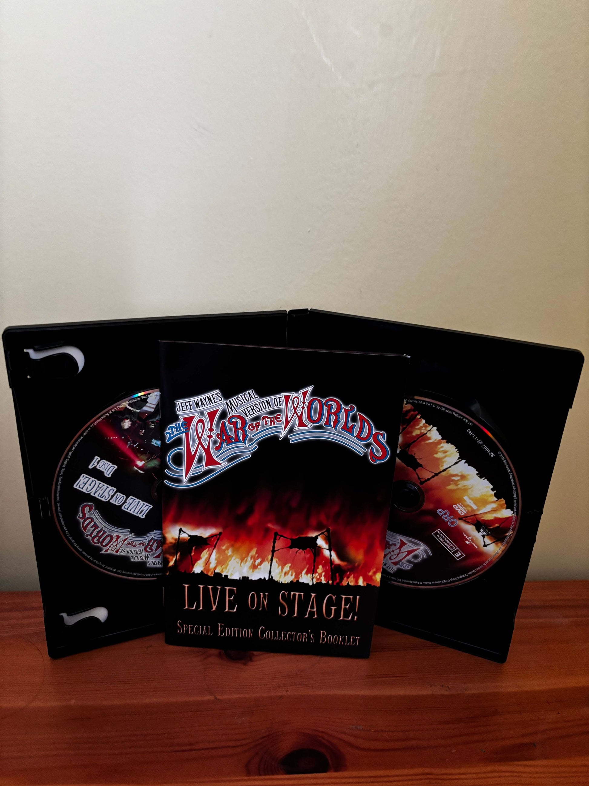 Product packaging with 'War of the Worlds' branding on a wooden surface.
