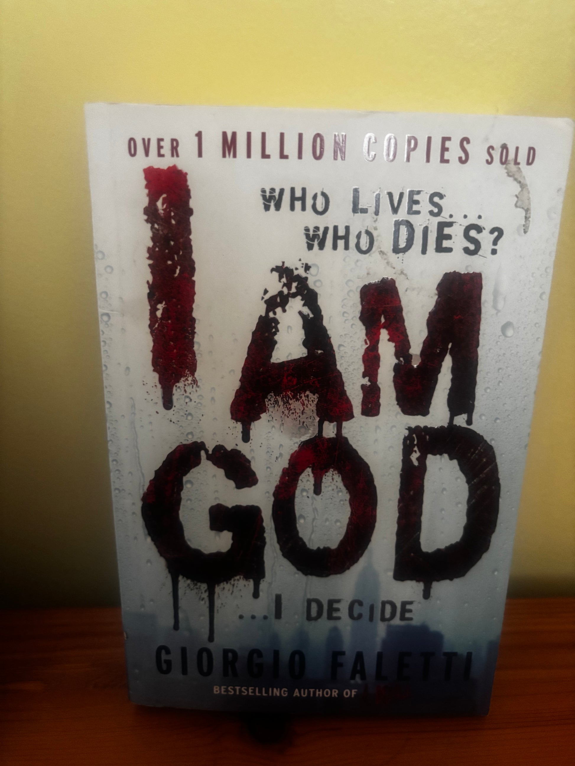 Book titled 'I Am God' by Giorgio Faletti on a yellow background