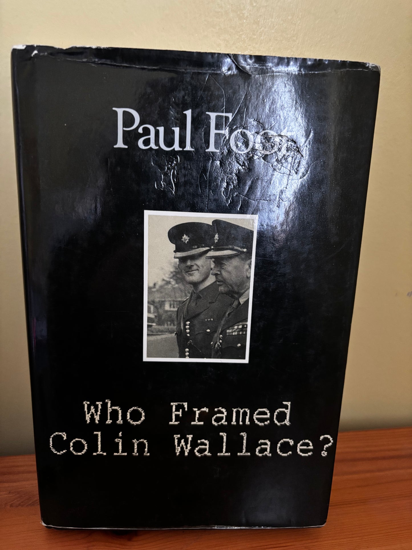 Book titled 'Who Framed Colin Wallace?' with a black cover and portrait of two men in uniform.