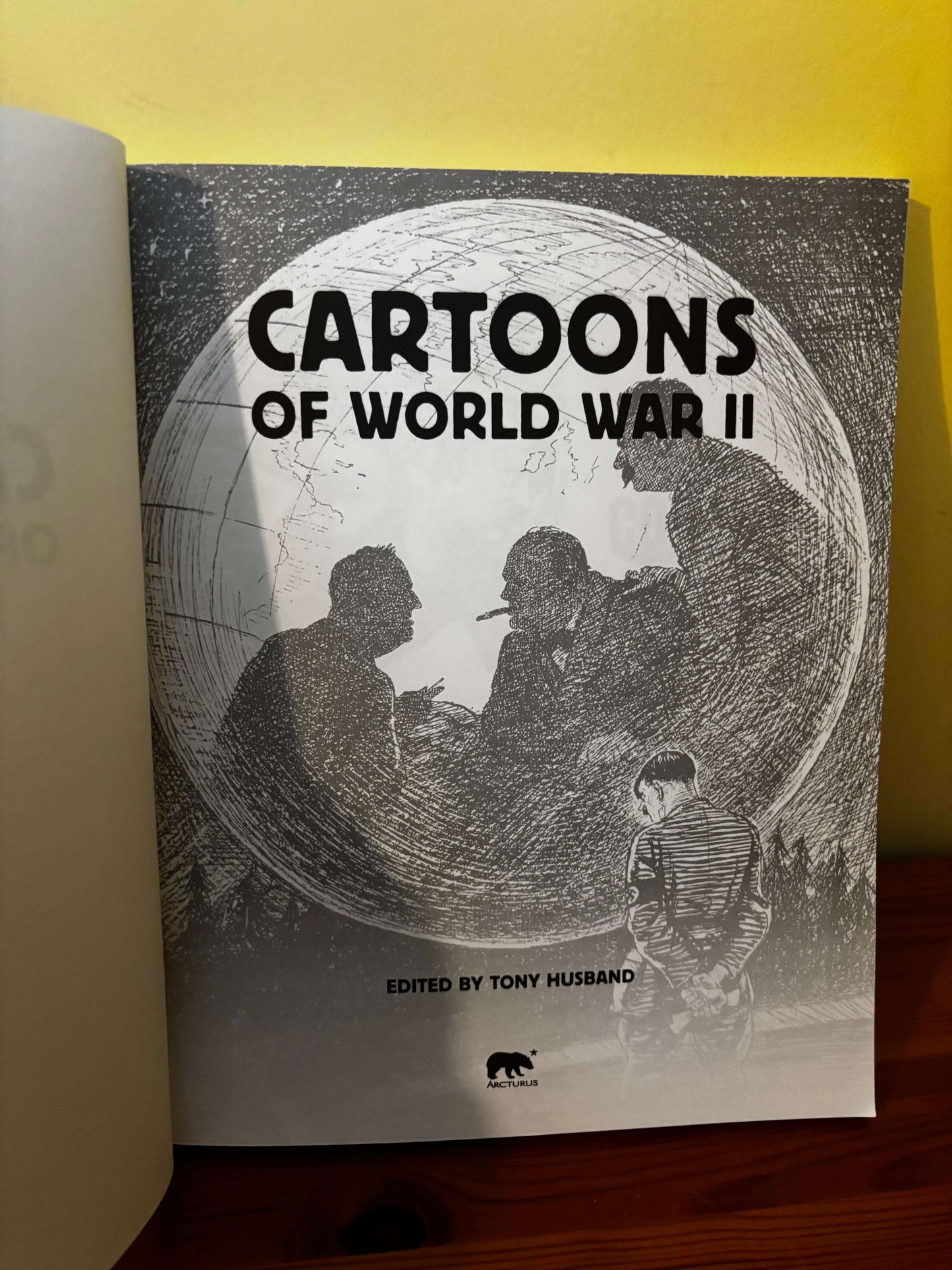 Book cover of 'Cartoons of World War II' with silhouettes and text on a yellow background