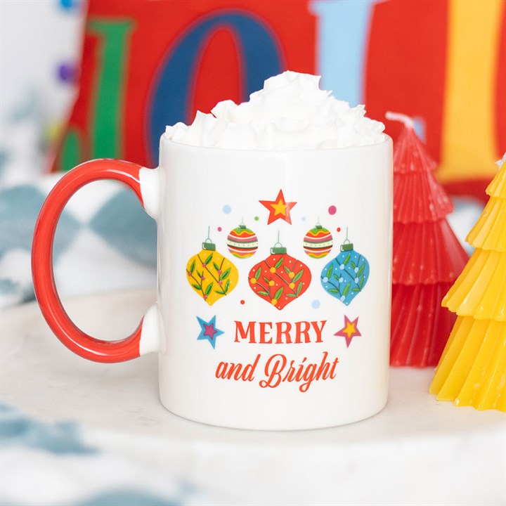 Brighten your day with the Merry and Bright Bauble Mug, featuring festive bauble designs and a vibrant red handle.