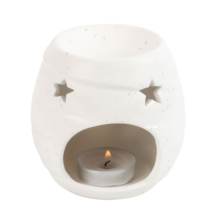 Mummy-shaped ceramic oil burner and wax warmer with star cutouts and tealight in the base.