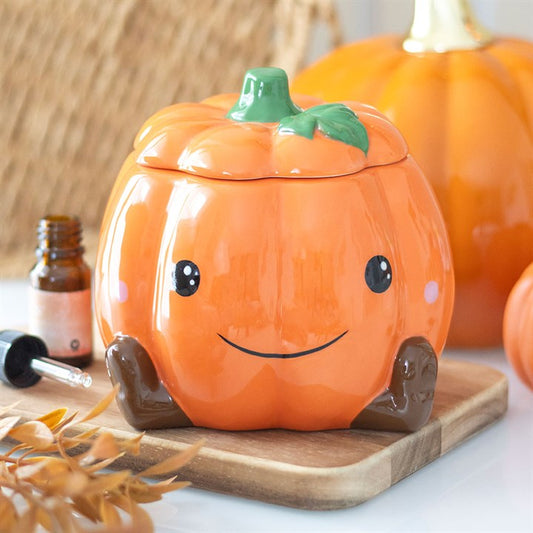Cute smiling ceramic pumpkin oil burner and wax warmer with removable lid and star cut-outs for cosy autumn fragrances.