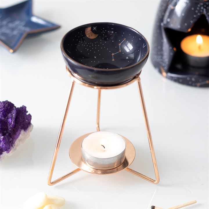 Purple star sign oil burner on a gold-coloured metal stand with a constellation bowl and gold details.