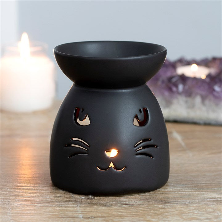 Black Cat Cut Out Oil Burner and Wax Warmer, matte black ceramic with cat-face cutouts and a warm glow.