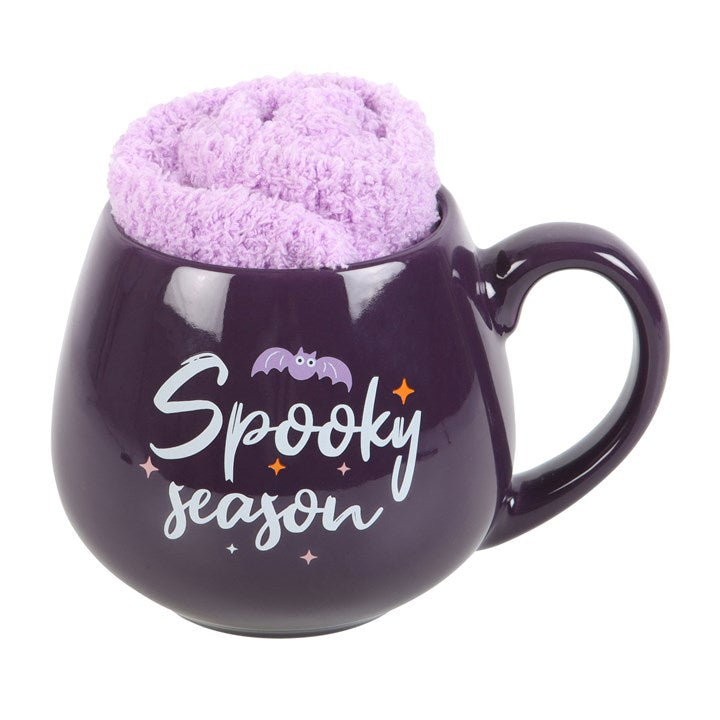 Delight in the Spooky Season Mug and Socks Set, featuring a purple mug and fluffy lilac socks for cosy autumn vibes.