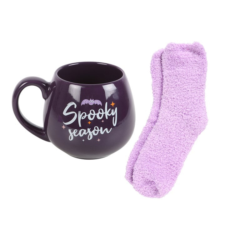 Delight in the Spooky Season Mug and Socks Set, featuring a purple mug and fluffy lilac socks for cosy Halloween vibes.
