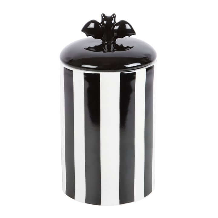 Striped ceramic bat storage jar with a bat-shaped lid; black and white vertical stripes, 20.5 cm tall.