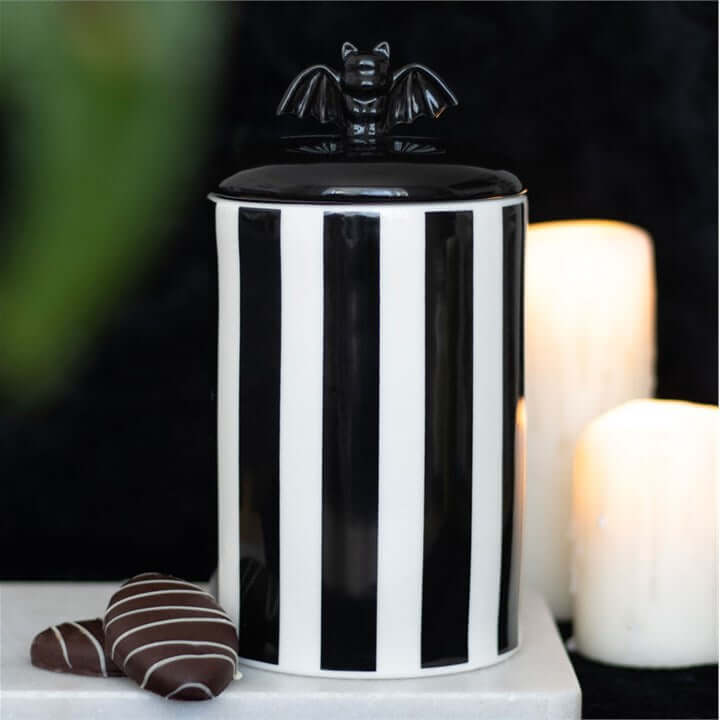 Striped ceramic bat storage jar with a black-and-white finish and bat finial lid; lift-off.