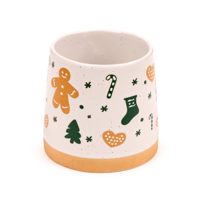 Gingerbread man stoneware mug with candy canes, stockings and trees on white, orange base.
