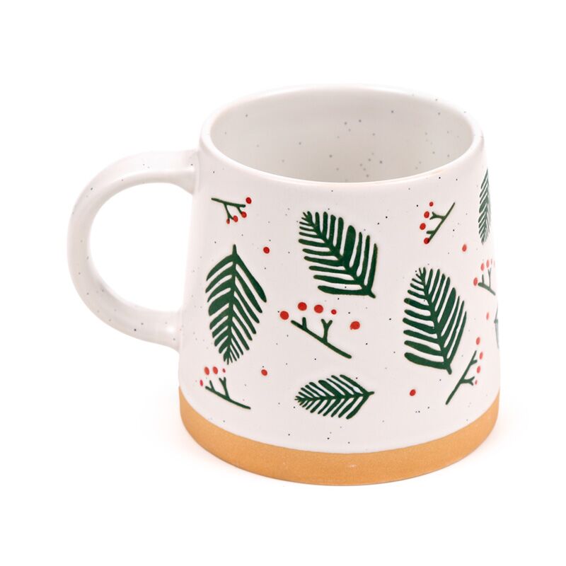 Stoneware mug with pine sprigs and red berries, white speckled glaze and orange base.