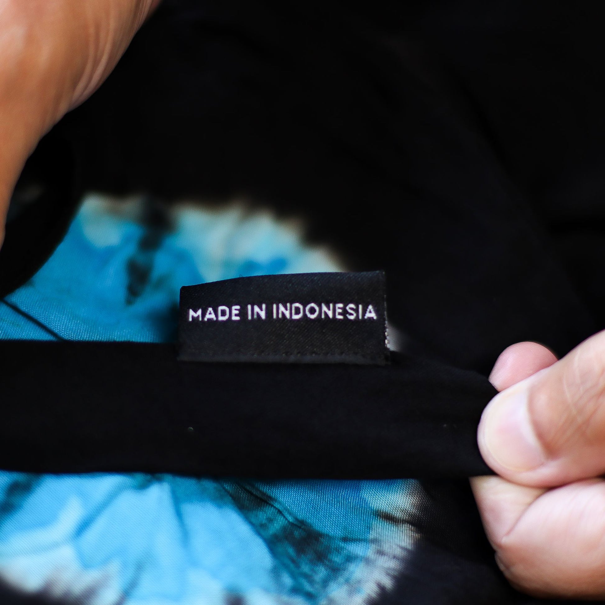 Made in Indonesia tag inside blue tie-dye lounge pants with black trim.