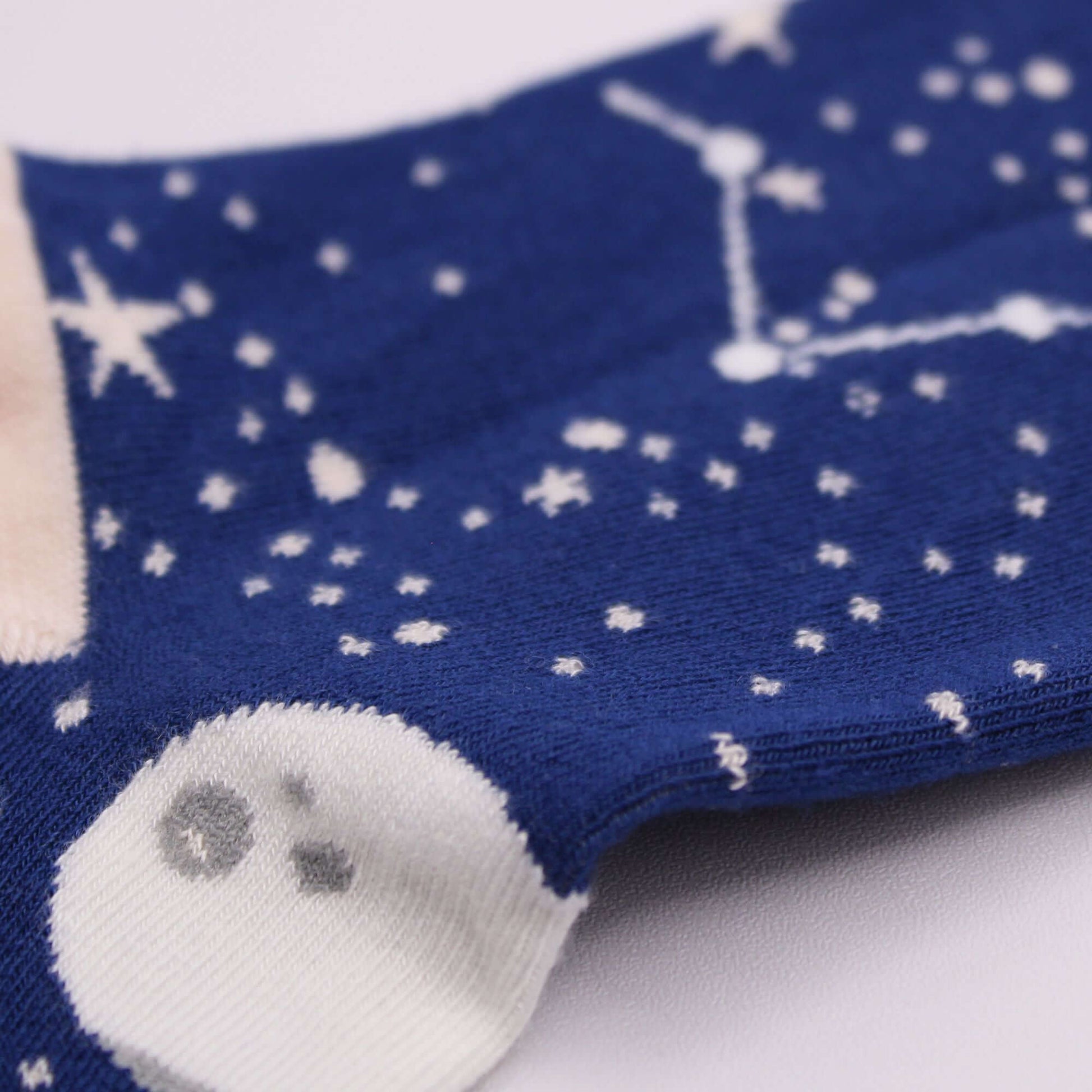 Hop Hare Bamboo Socks S/M - Moon Walk with celestial designs and starry patterns in blue fabric close-up.