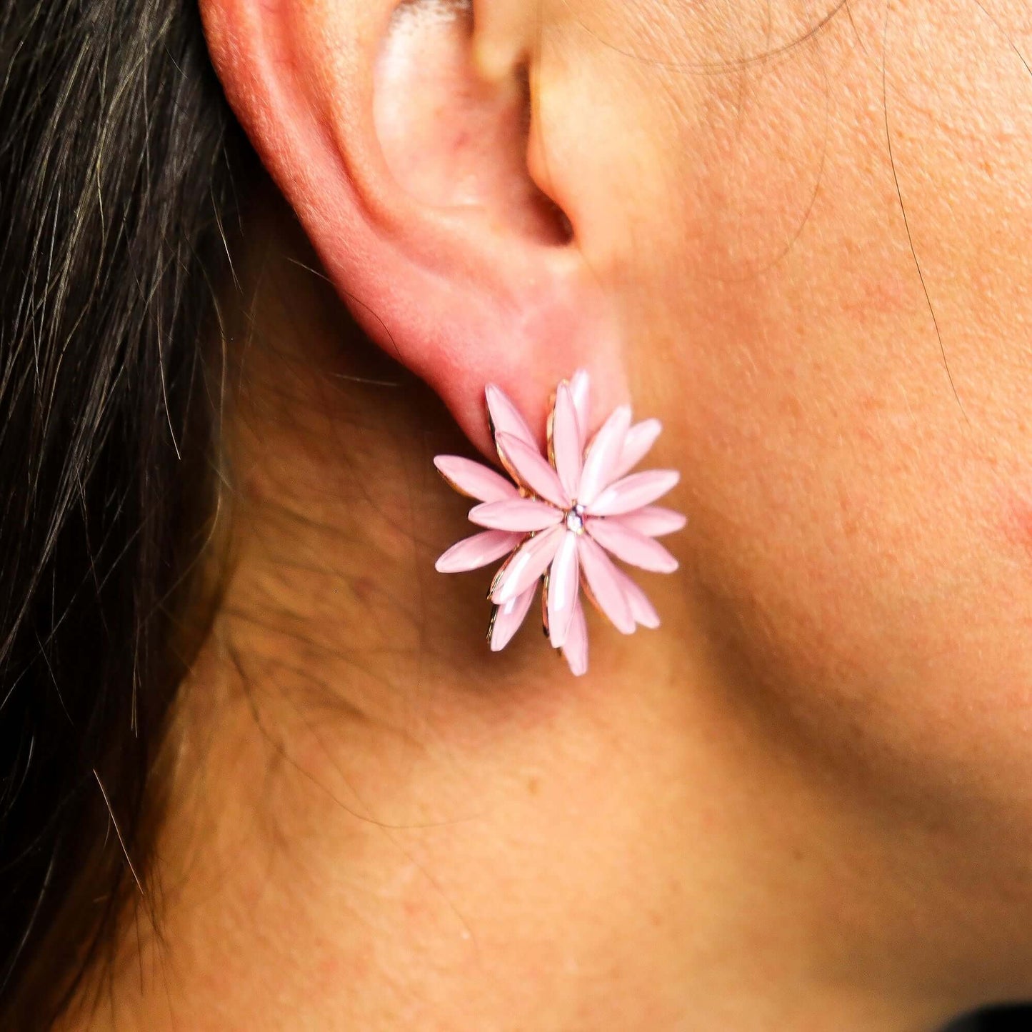 Soft pink vintage glass flower earring worn on the earlobe.