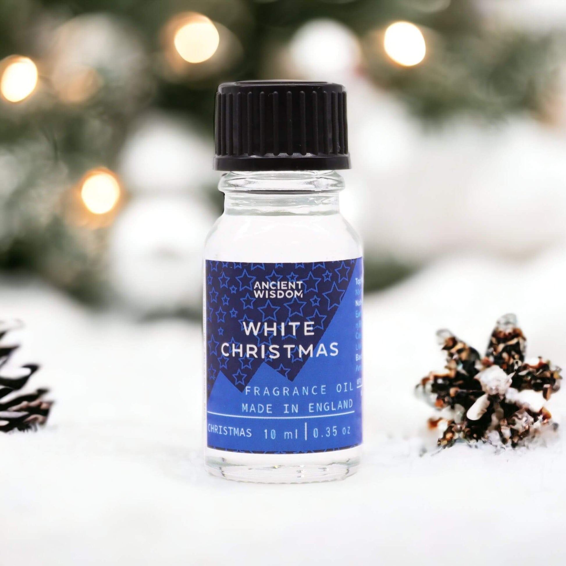 White Christmas Fragrance Oil 10ml bottle displayed with pine cones, evoking a festive winter atmosphere.