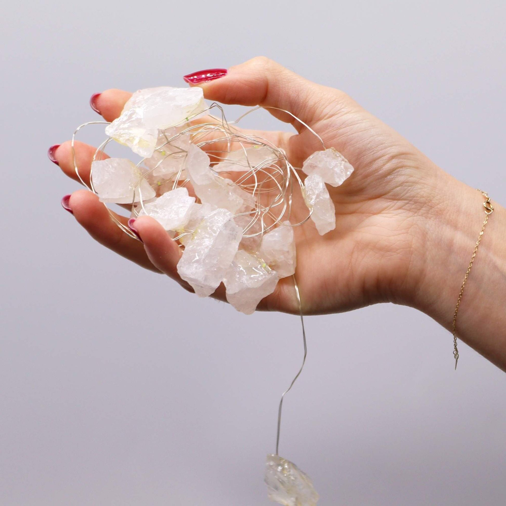 Gemstone Enchantment Lights Rock Quartz Crystal String Lights USB held in hand with glowing crystals.