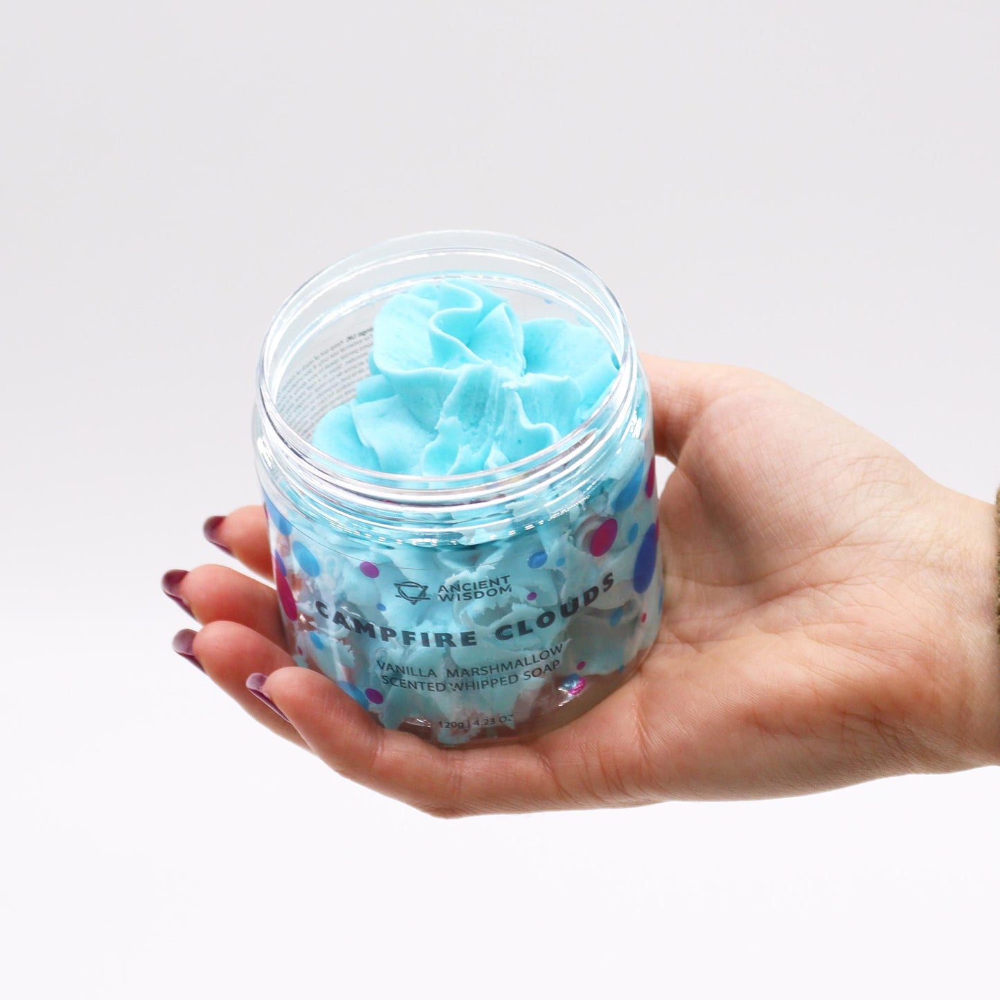 Marshmallow Whipped Soap 120g in a clear jar with blue whipped swirl, held in a hand.