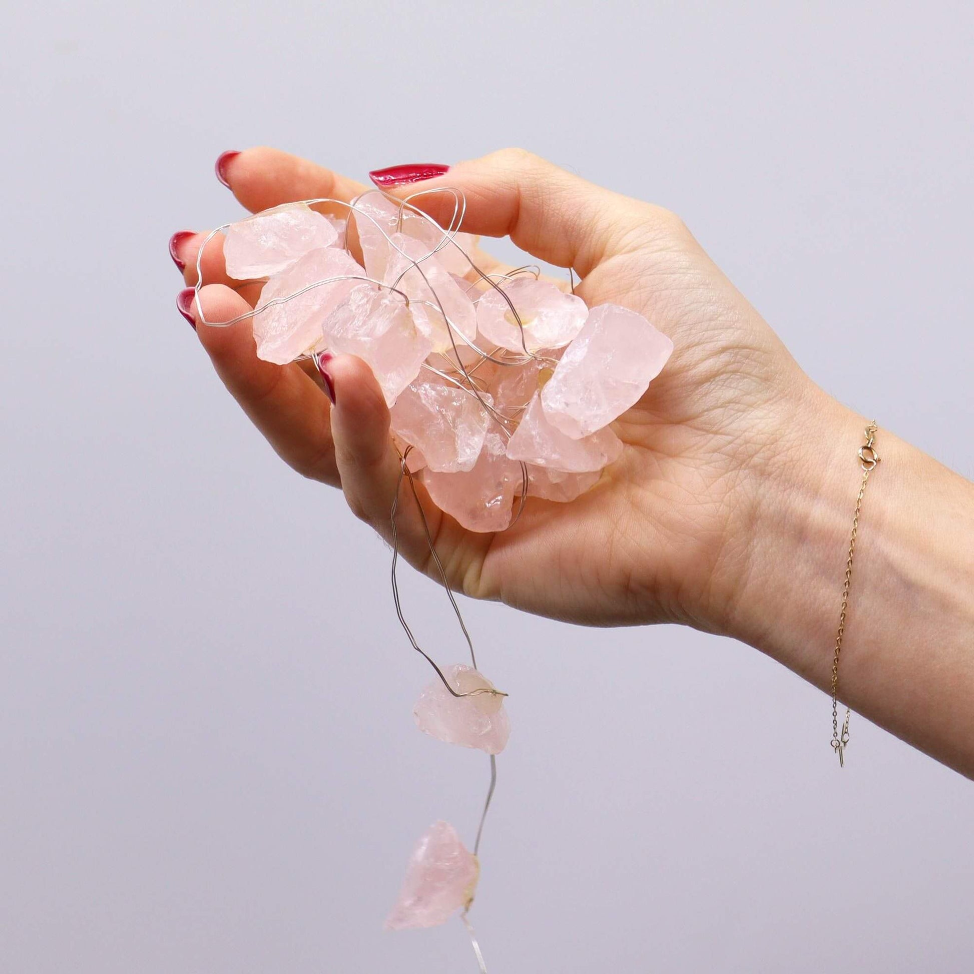 Rose Quartz Gemstone Enchantment Lights USB Powered with crystal stones in hand, glowing gently.