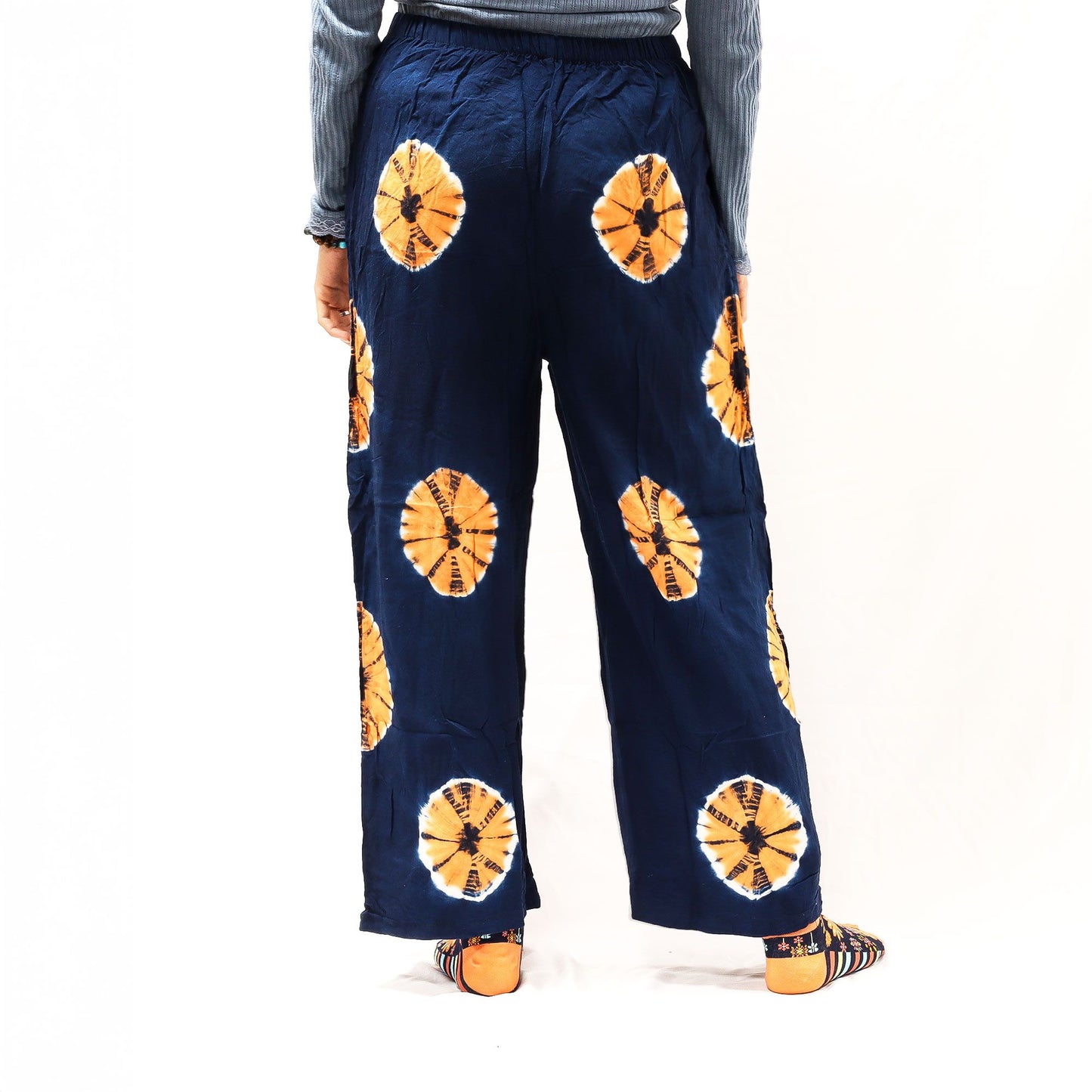 Medium navy blue Japanese-style lounge pants with orange circular tie-dye motifs; linen-rayon blend.