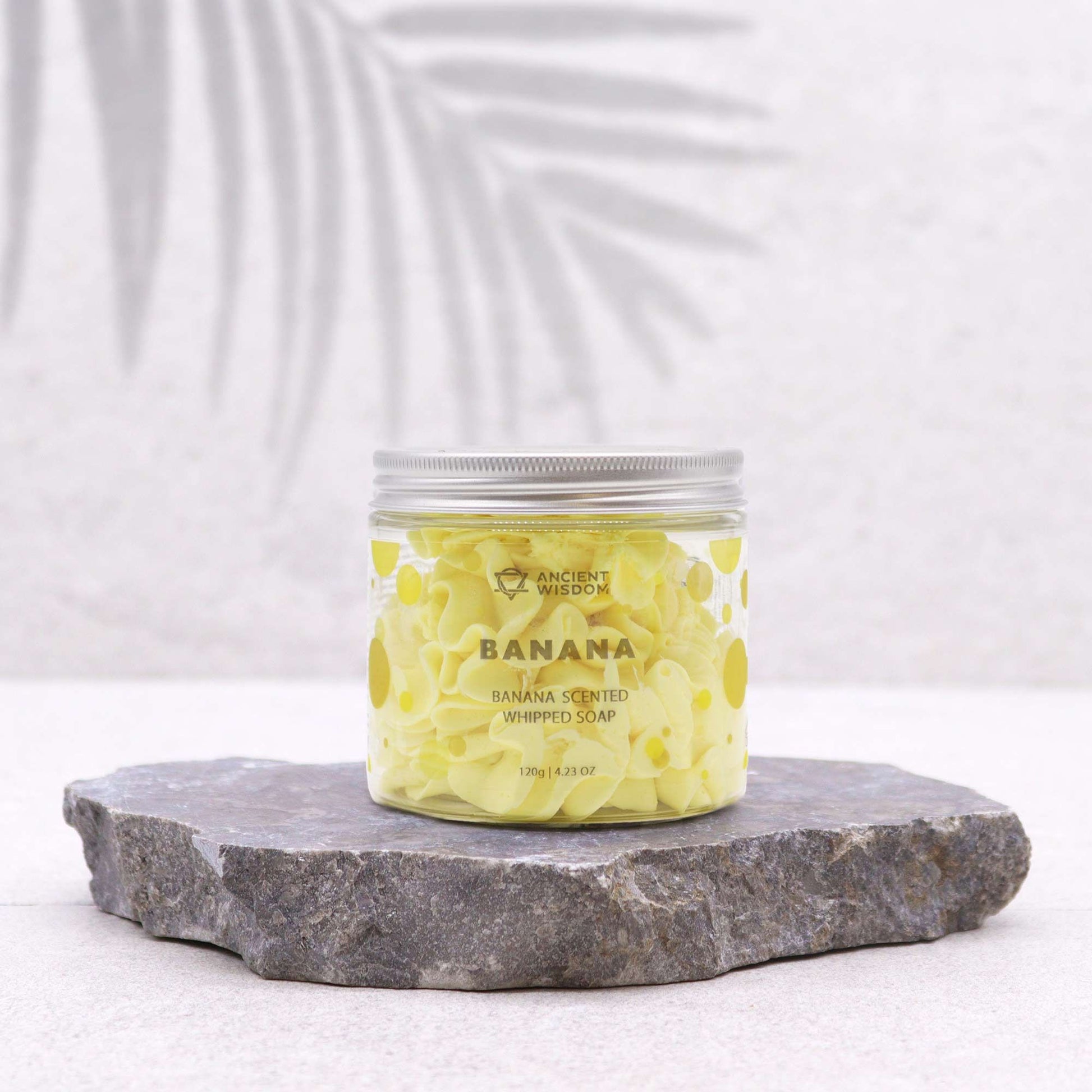Banana scented whipped soap 120g jar with yellow banana swirl on a slate pedestal.