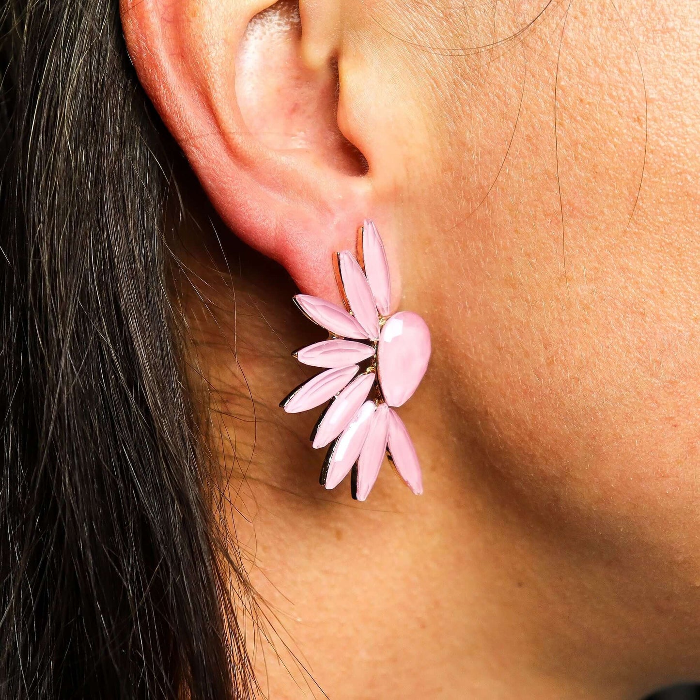 Pink flower earring with petal-shaped beads surrounding a central pink bead on the earlobe