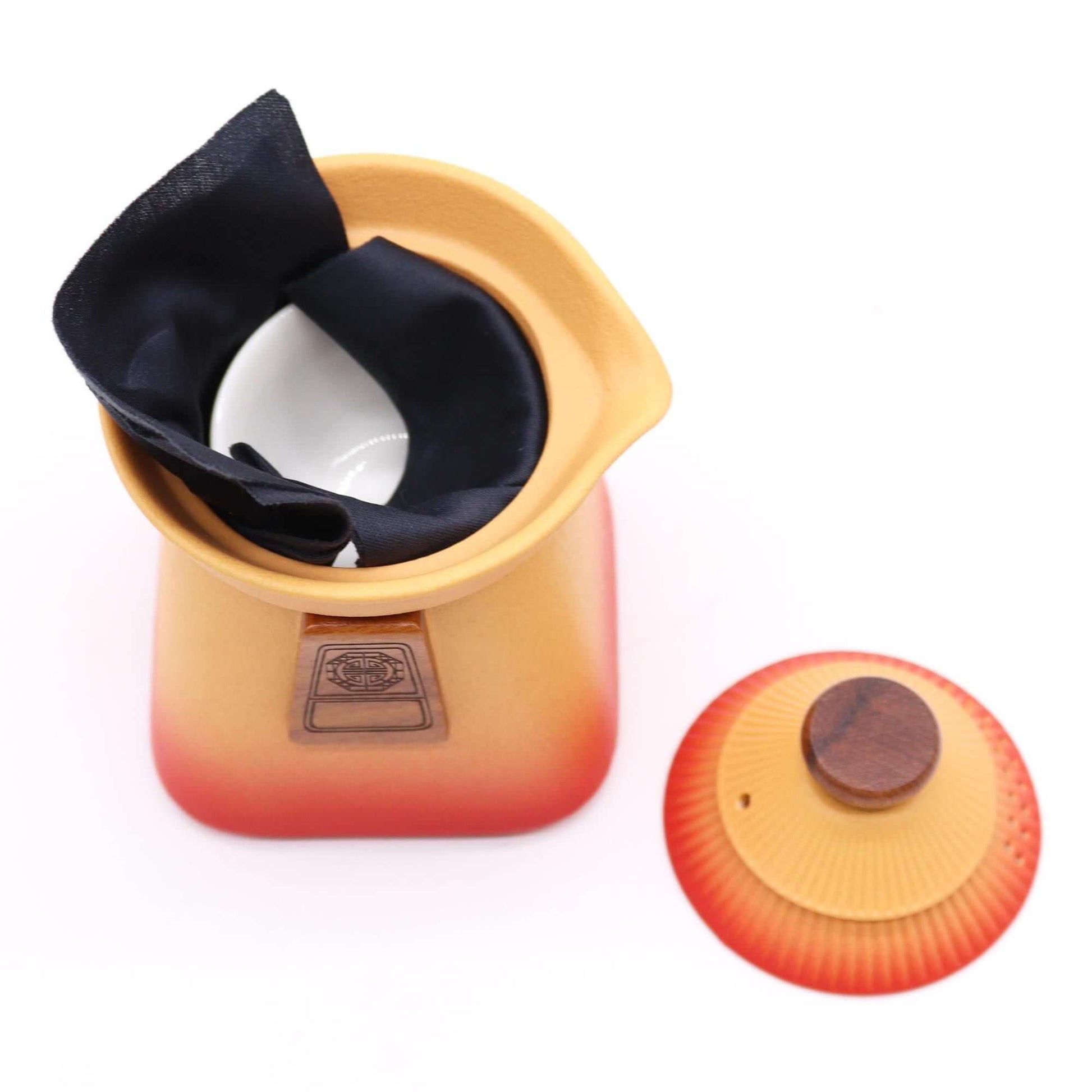 Temple Teapot Set & Three Cups - Orange Earth with teapot lid and cup inside, showcasing the artistic design.