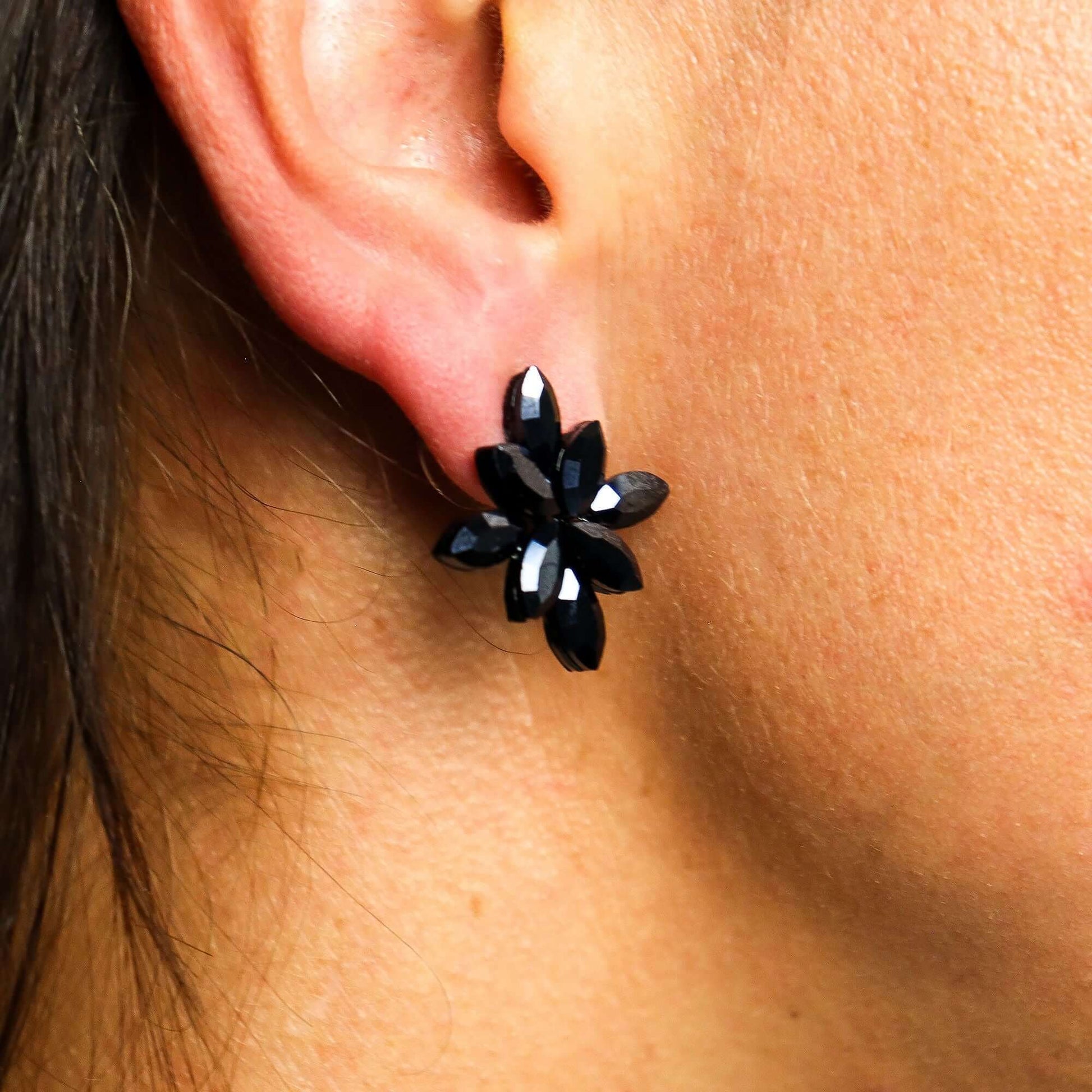 Jet Black Vintage Glass Flower Earrings With Stainless Steel Posts worn on ear, showcasing flower design with polished petals.
