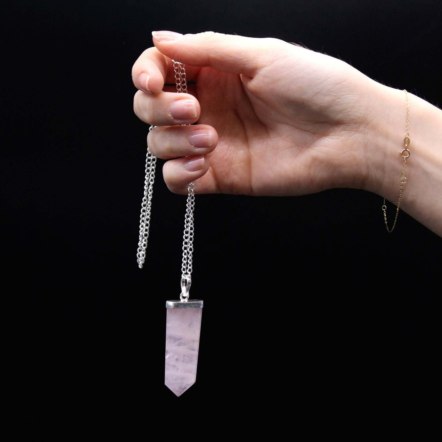 Rose Quartz Flat Pencil Pendant Necklace Gemstone Silver Plated Chain displayed in a hand against a black background.