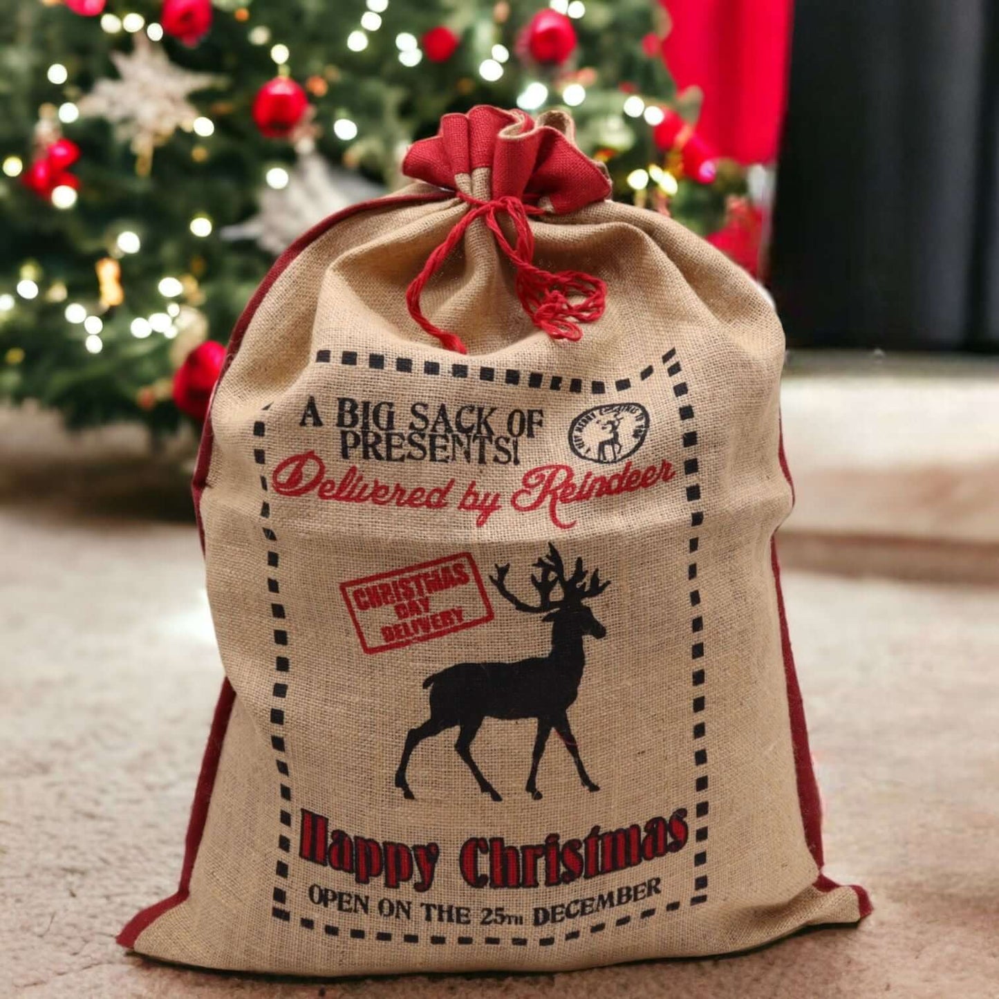 Delivered By Reindeer Jute Sack For Christmas Gifts Reusable with festive reindeer design and red accents.