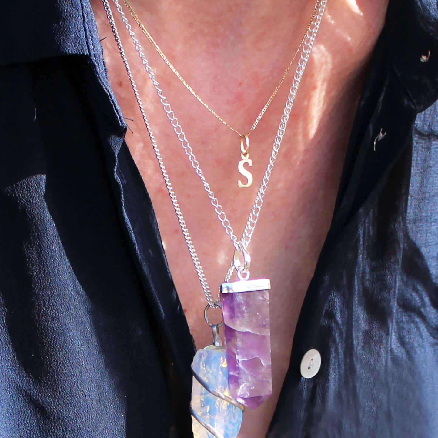 Rock Quartz Flat Pencil Pendant Necklace in Silver Plated worn with additional layered necklaces.