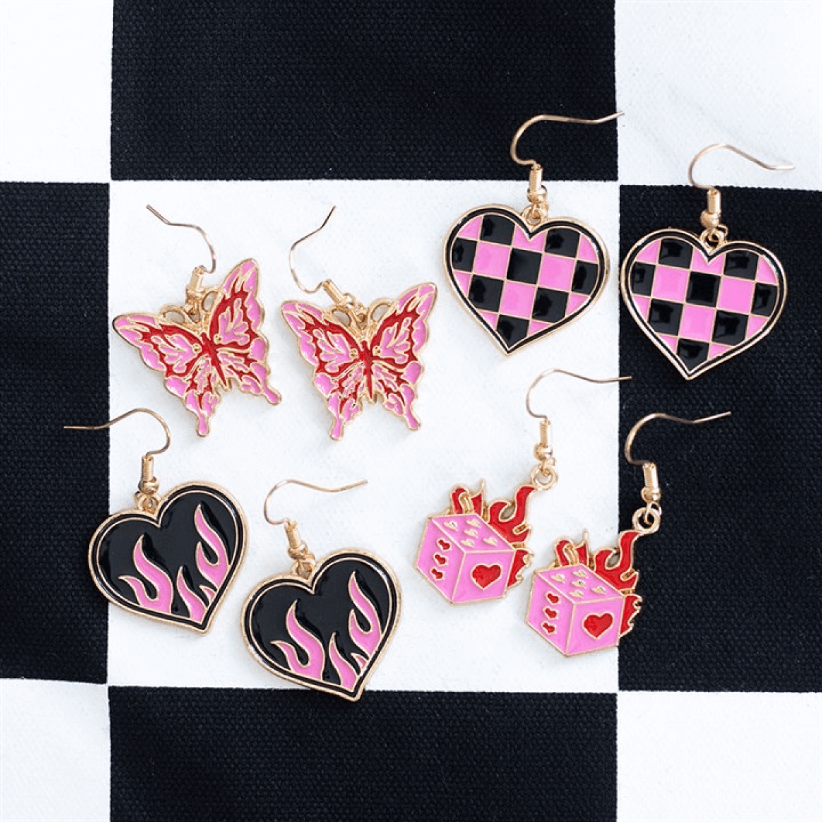 Burning Heart Earrings, pink and black flame enamel statement jewellery, edgy design on checkered background.