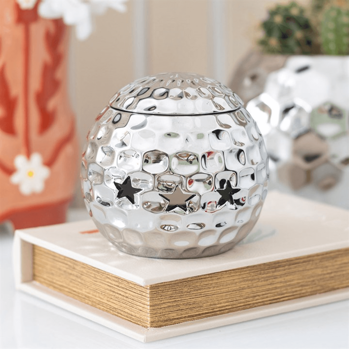 Silver disco ball oil burner, dolomite, star cutouts; 10 cm high by 10.7 cm wide; for fragrance oil diluted with water.