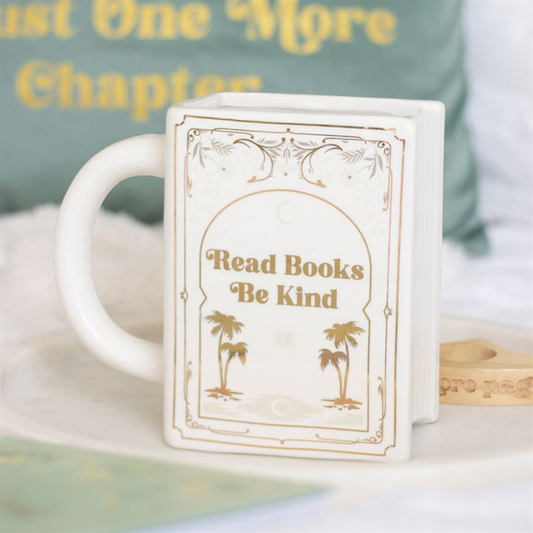 White book-shaped ceramic mug with gold 'Read Books Be Kind' inscription and palm trees.