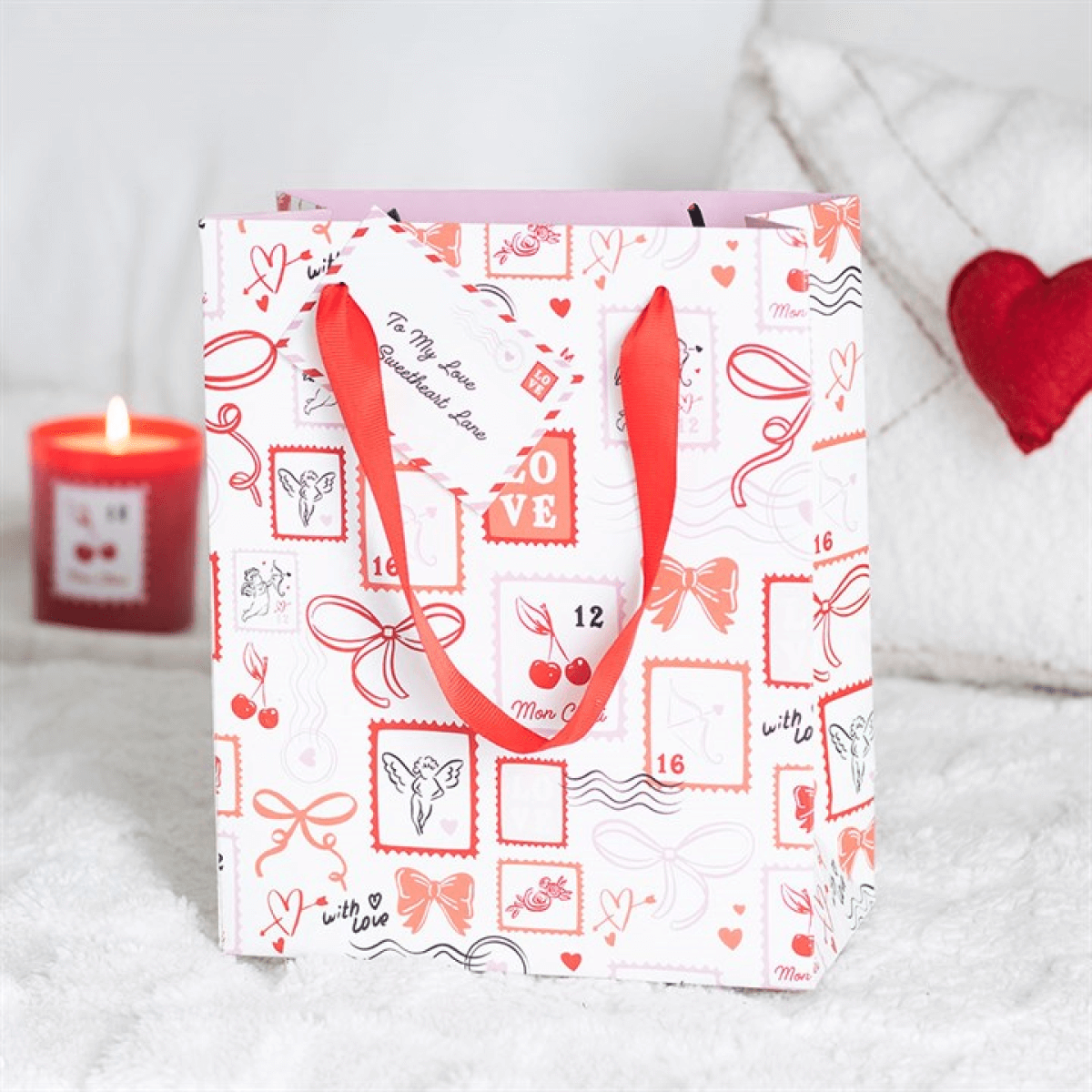 Valentine postage stamp gift bag with red handles and decorative prints, perfect for special gift presentations.